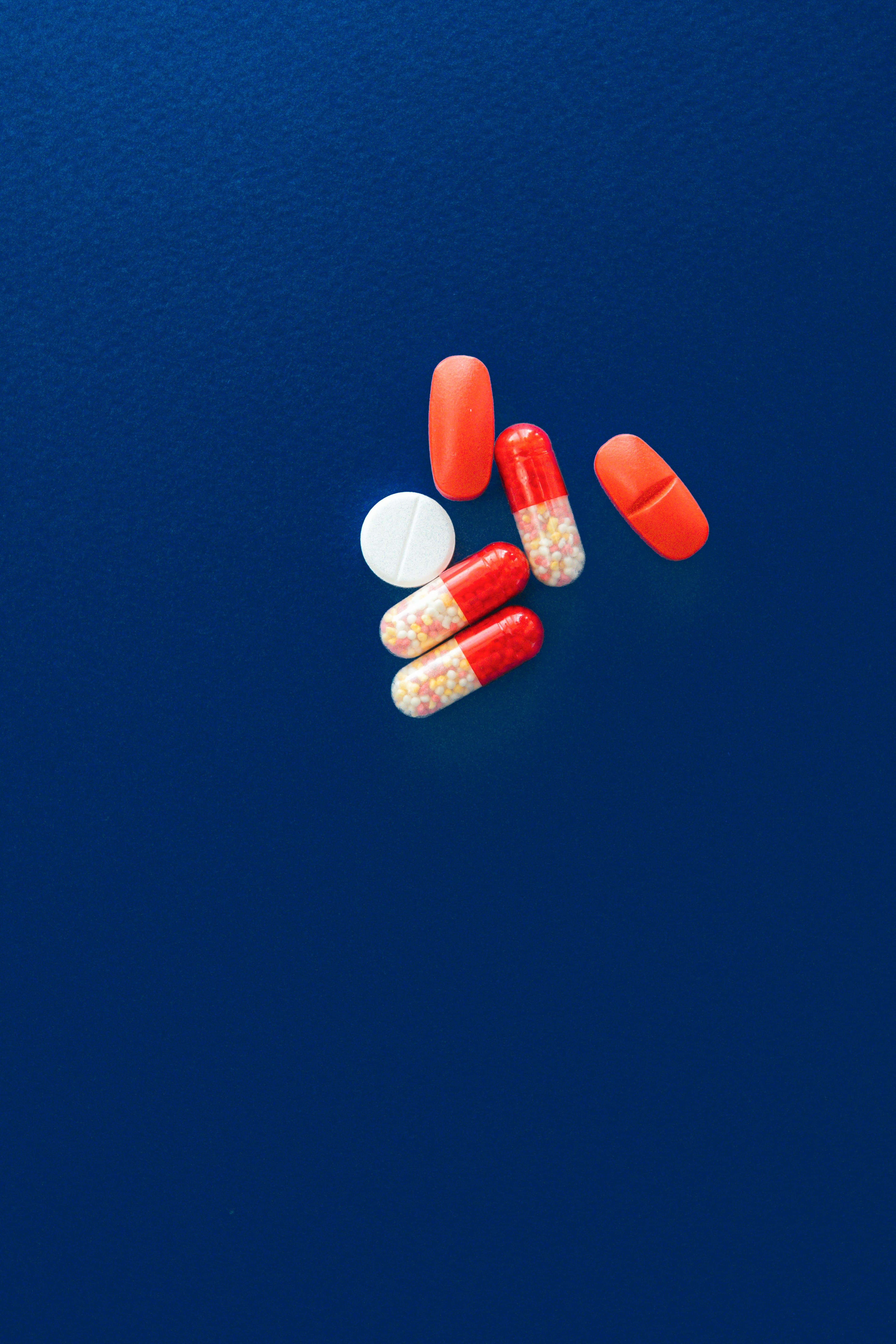 Capsules and tablets on a blue surface